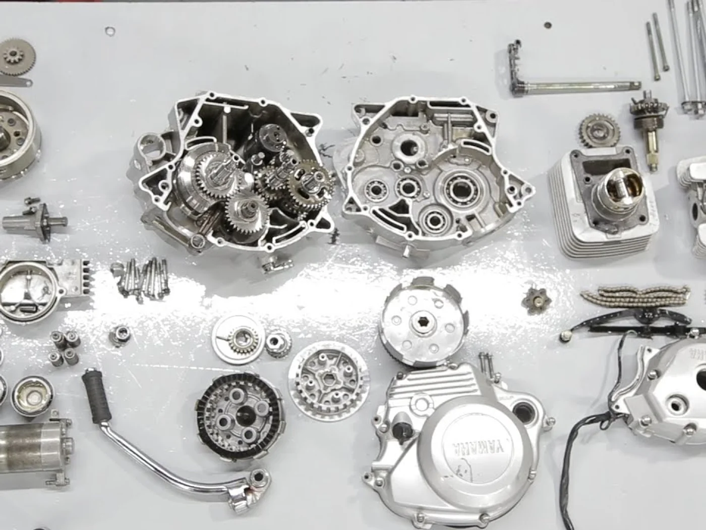 Piezas de un motor de moto desarmadas y ordenadas sobre el banco de trabajo
